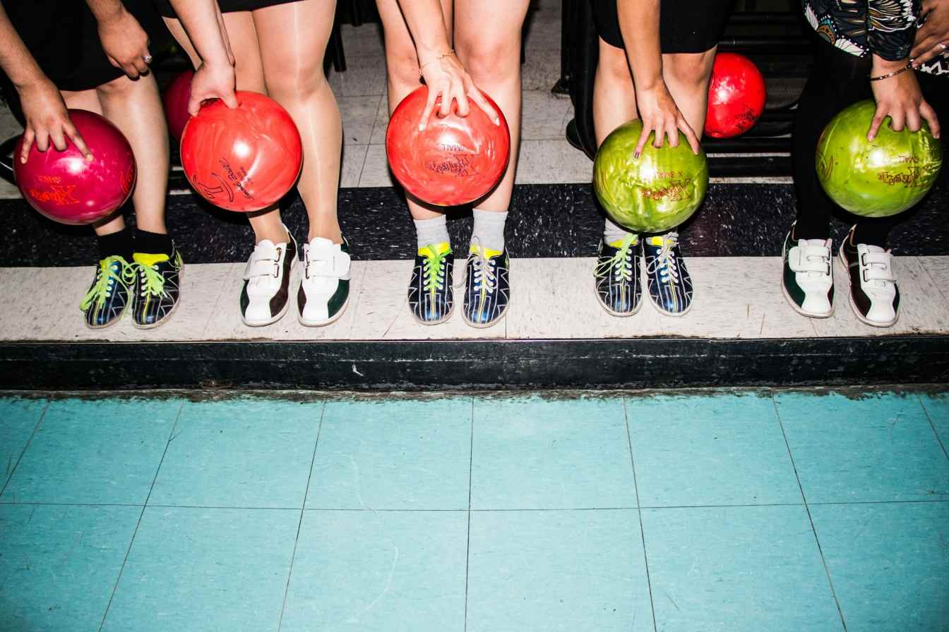 Five people holding bowling balls